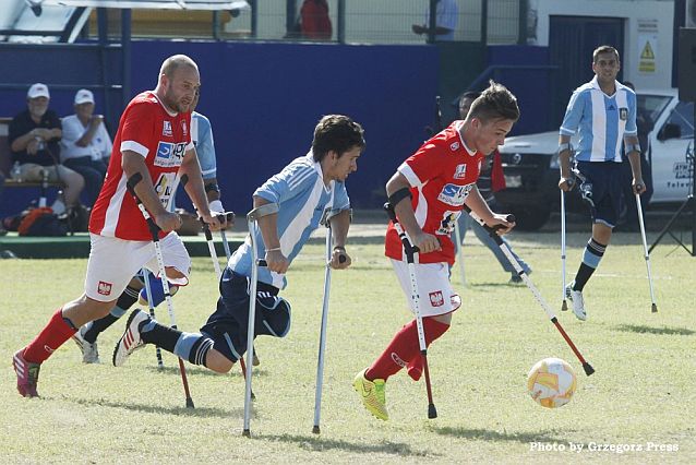 Mecz ampfutbolu Polska-Argentyna. Polski zawodnik przy piłce, za nim biegnie Argentyńczyk