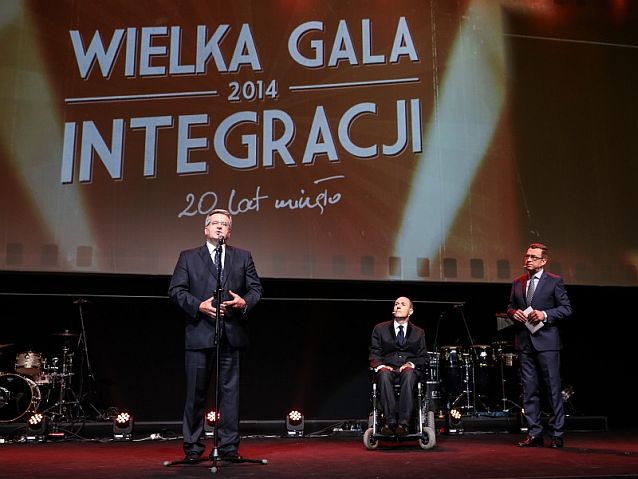 Prezydent przemawia na scenie podczas Wielkiej Gali Integracji. Obok słuchają: Piotr Pawłowski i Maciej Orłoś