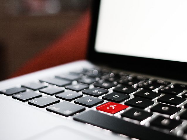 Laptop z czerwonym klawiszem z symbolem osoby na wózku