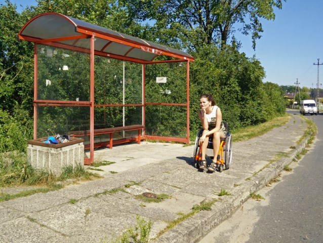 dziewczyna na wózku wypatruje autobusu