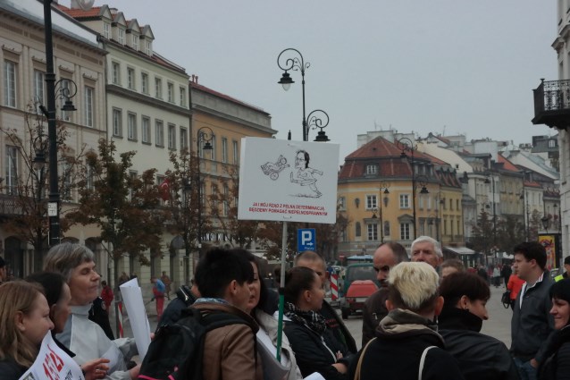 tabliczka z Ewą Kopacz, która kopie dziecko z niepełnosprawnością oraz napis Ja i mój rząd będziemy pomagać niepełnosprawnym