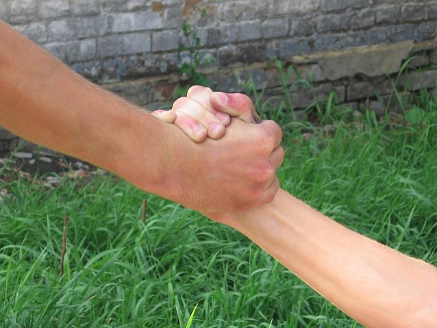 Pomocna dłoń jednej osoby trzymająca drugą