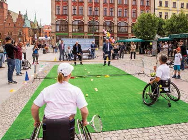 dwie osoby na wózku w jednej parze grają w tenisa z osobami pełnosprawnymi na wrocławskim rynku