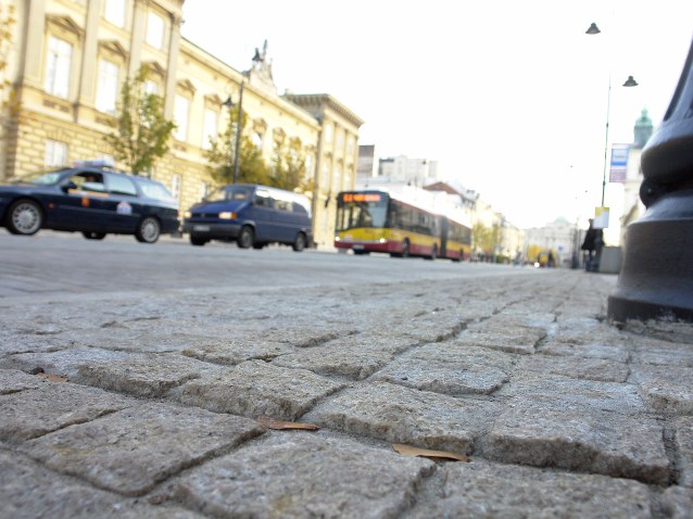 bruk chodnika na jednej z warszawskich ulic. W tle samochody i autobus