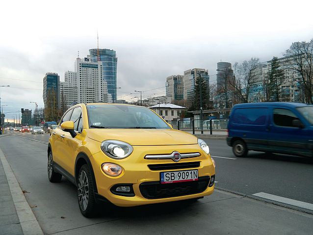 Żółty Fiat 500X na ulicy, w tle wieżowce