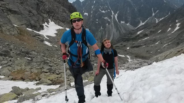 mężczyzna bez nogi na kulach wspina się w górę po śniegu