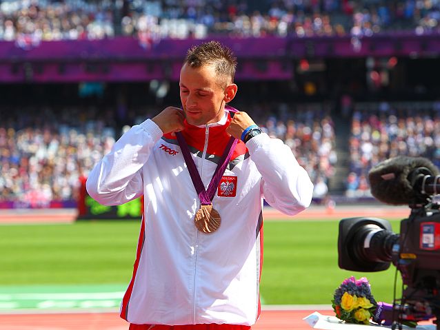 Polski sportowiec z medalem na szyi, obok niego kamera