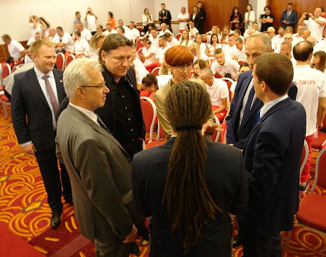 Łukasz Szeliga rozmawia z politykami w sali przed uroczystością pożegnania paraolimpijczyków