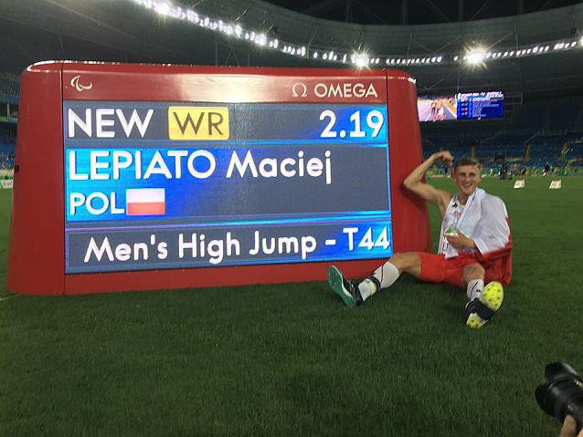 Maciej Lepiato siedzi przed tablicą świetlną, oznajmiającą pobicie przez niego rekordu świata 