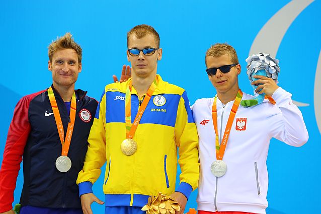 Trzech medalistów stoi z medalami na szyjach, wśród nich Wojciech Makowski