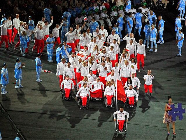 Reprezentanci Polski wchodzą na płytę stadionu. Prowadzi ich z flagą poruszający się wózkiem Rafał Wilk