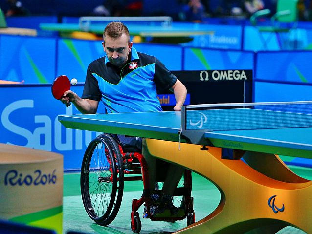 Rafał Czuper gra na wózku w tenisa stołowego