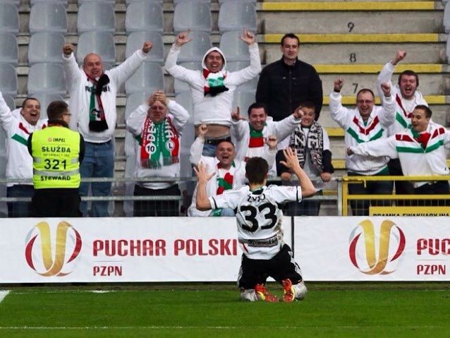 kibice na trynunach w geście radości