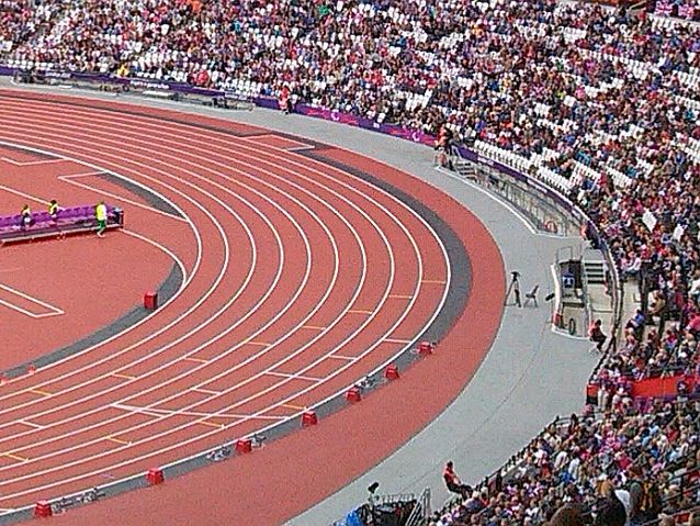 Fragment łuku bieżni i tłumów na trybunach stadionu w Londynie