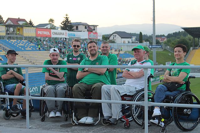Kibice Śląska Wrocław siedzący na wózkach na koronie niewielkiego stadionu