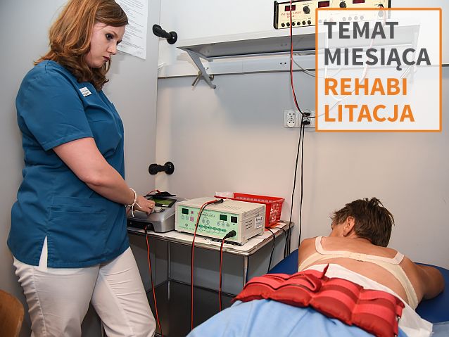 rehabilitantka stoi nad łóżkiem, na którym leży na brzuchu kobieta.