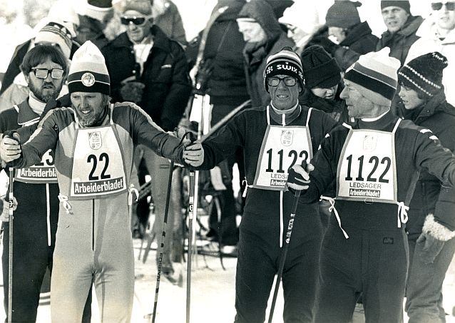 Czarno-białe zdjęcie z 1980 roku przedstawiające biegaczy na nartach stojących na starcie