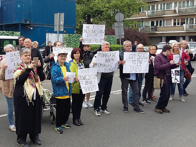 Manifestujący stoją na ulicy z transparentami