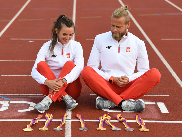 Asia Mazur i Michał stawicki siedzą na bieżni, przed nimi leżą ich medale w liczbie ośmiu