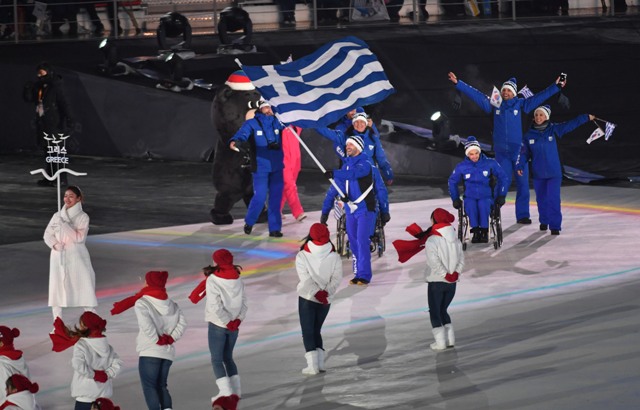 Około siedmioosobowa reprezentacja Grecji wchodzi na płytę stadionu w niebieskich strojach