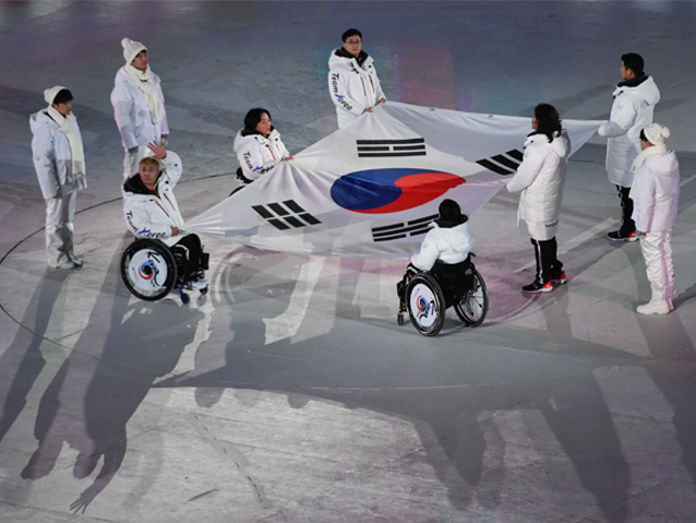 Koreańczycy z niepełnosprawnością trzymają flagę Korei Południowej