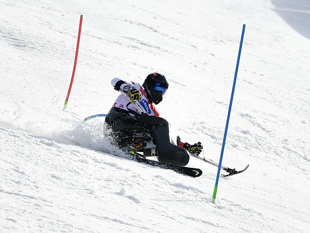 Igor Sikorski mija tyczki podczas slalomu w pozycji siedzącej