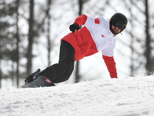 Wojciech Taraba podpiera się ręką podczas jazdy na snowboardzie