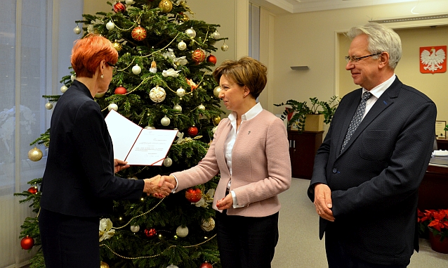 Marlena Maląg odbiera nominację ściskając dłoń Elżbiety Rafalskiej, obok stoi Krzysztof Michałkiewicz