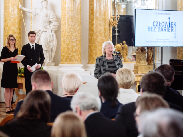 od lewej: prowadzący galę konkursu Człowiek bez barier: Paulina Malinowska-Kowalczyk i Tomasz Kammel, przy mikrofonie prof. Antonia Ostrowska