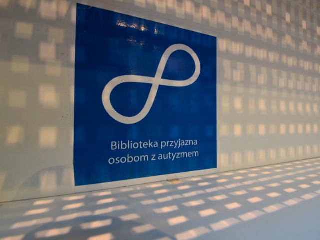 niebieski znaczek z napisem biblioteka przyjazna osobom z autyzmem