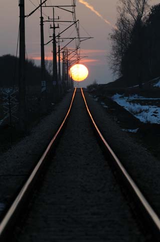 zachodzące słońce nad torami kolejowymi