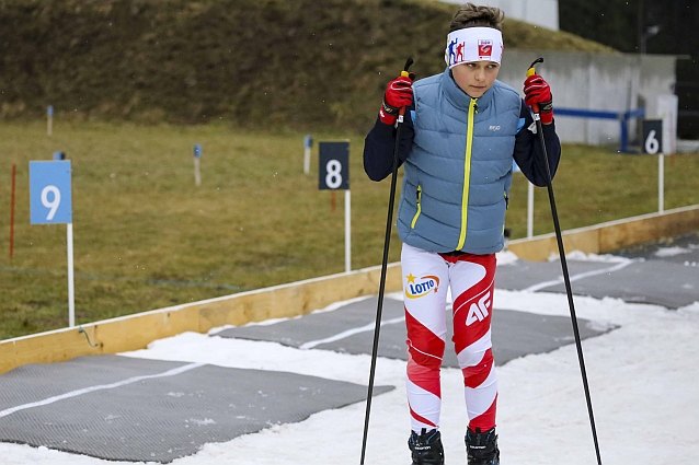 Młody narciarz stoi na strzelnicy biathlonowej