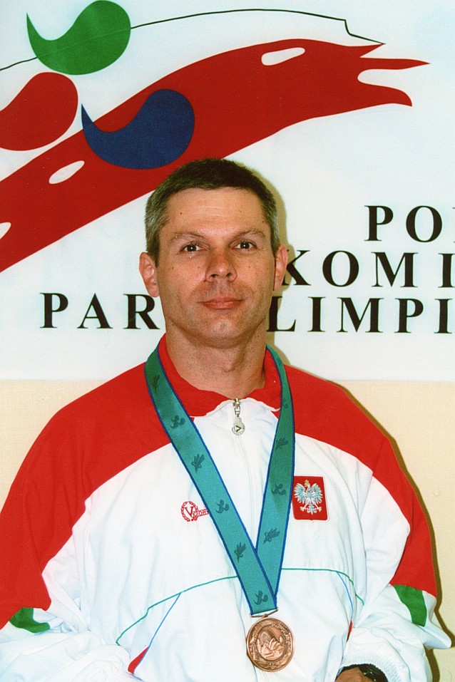 Arkadiusz Pawłowski pozuje do zdjęcia w dresie reprezentacji Polski i z medalem na szyi