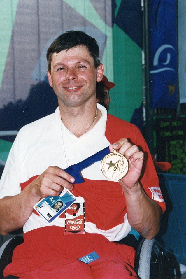 Arkadiusz Pawłowski na wózku prezentuje swój medal z Atlanty 1996