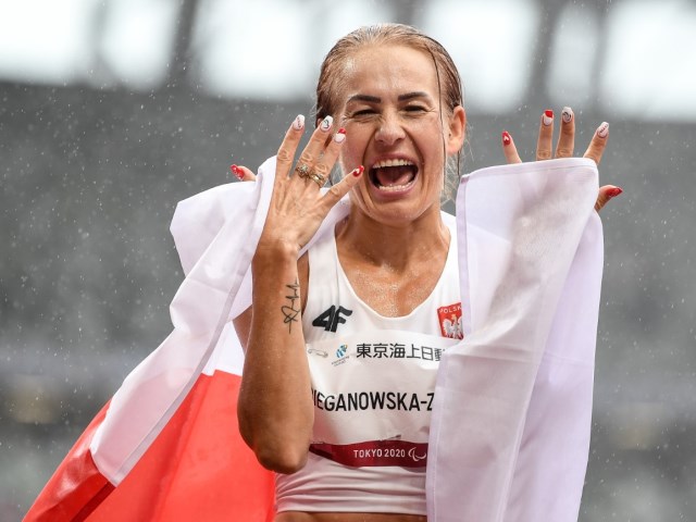 barbara bieganowska zając owinięta polską flagą z okrzykiem radości na ustach i twarzy