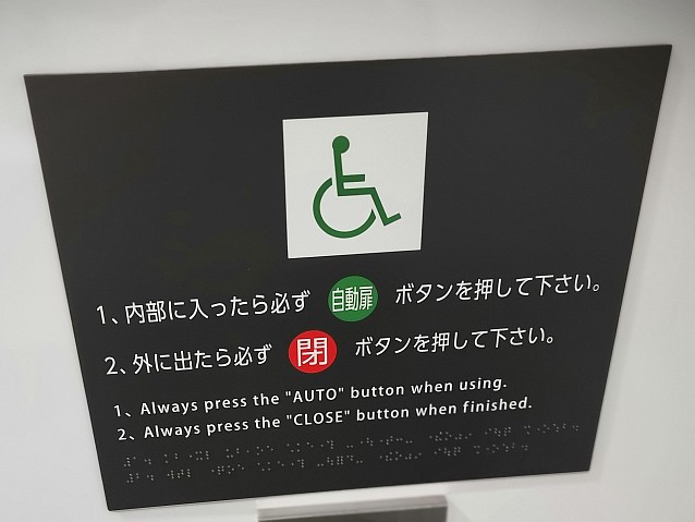 Symbol wózka na ścianie. Pod nim napisy po japońsku i angielsku