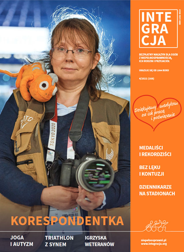 okładka magazynu Integracji nr 4/2021. Na okładce Ilona Berezowska patrzy prosto w obiektyw, ma okulary, jest ubrana w kamizelkę korespondentki z Tokio, trzyma aparat w dłoniach, ma maskotkę na ramieniu