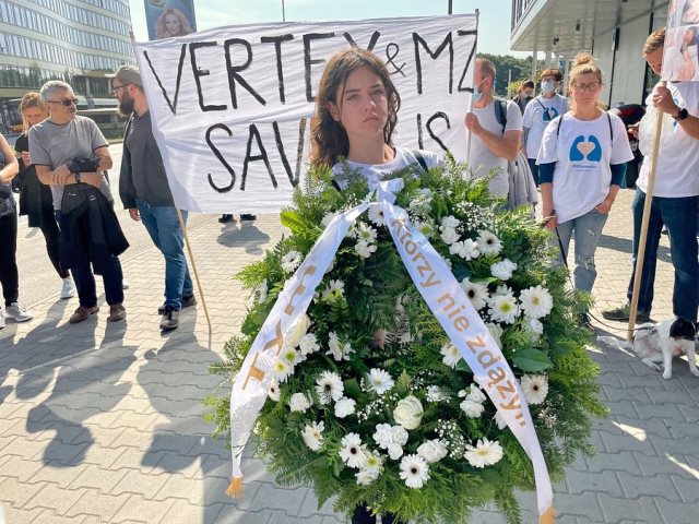 młoda dziewczyna na czele manifestacji niesie żałobny wieniec