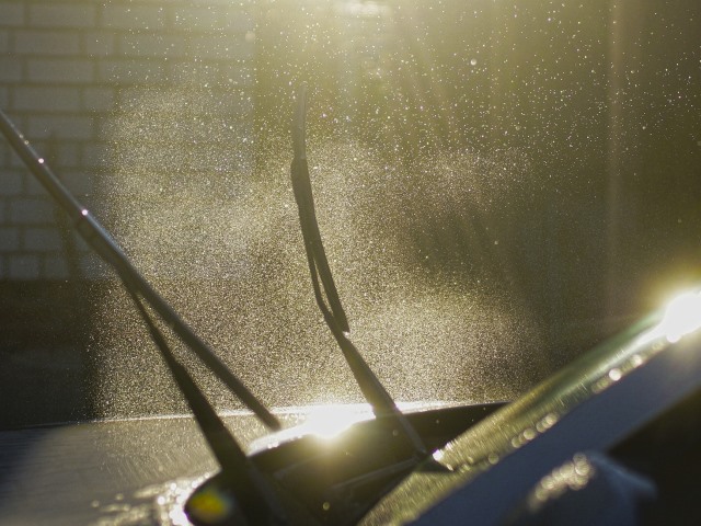 samochód w myjni ma podniesione wycieraczki widać kropelki wody wokół