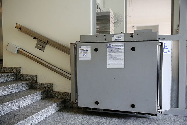 Dość staro wyglądająca złożona platforma przyschodowa na dole schodów