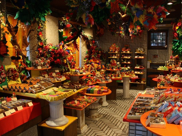 Wnętrze sklepu z kolorowymi słodyczami, wyłożonymi po obu stronach