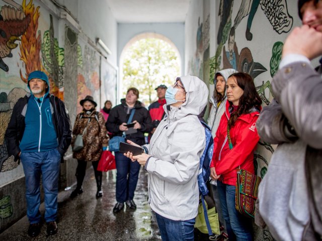 kilka osób stoi w przejściu, gdzie są artystyczne graffiti