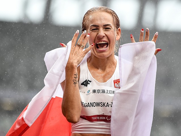 Barbara Bieganowska-Zając krzyczy z radości, trzymając polską flagę