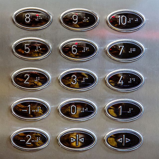 Panel windy z opisanymi w brajlu przyciskami od kondygnacji -2 do 10
