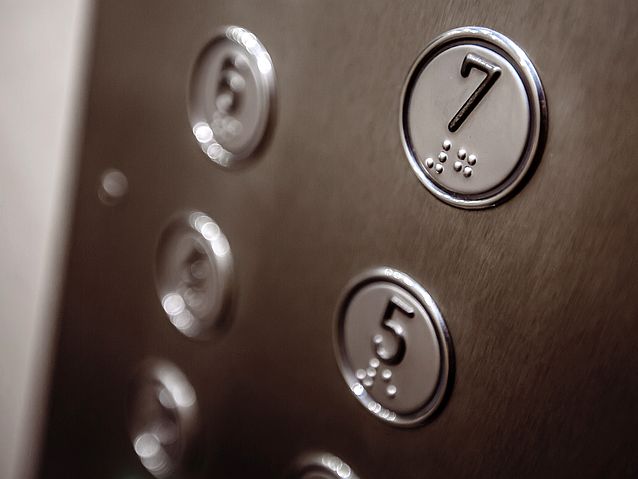 Panel windy z klawiszami pięter 7 i 5. Na klawiszach numery w brajlu