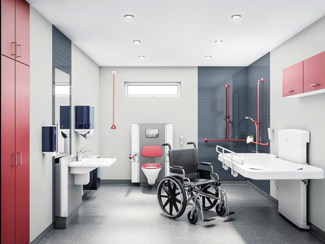 dostosowana łazienka, na jej środku stoi wózek w typie inwalidzkim