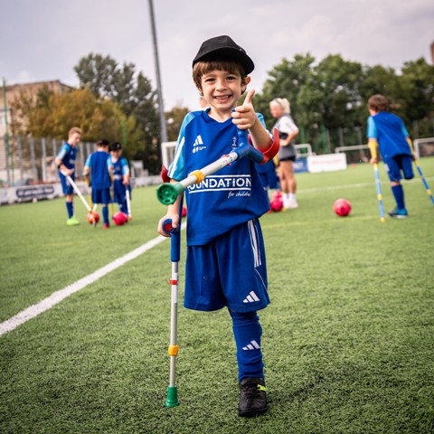 Chłopiec uprawiający ampfutball i trzymający kciuka w górę.