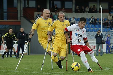 Trzech zawodników poruszających się o kulach walczy o piłkę w czasie meczu ampfutbolu. Na pierwszym planie reprezentant Polski, za nich dwóch graczy Ukrainy