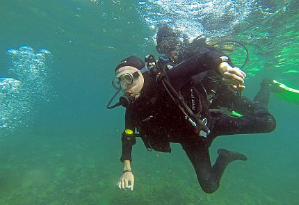 Autor w kombinezonie nurkuje w niebieskozielonej wodzie Oceanu Atlantyckiego. Za nim nurkuje asystent