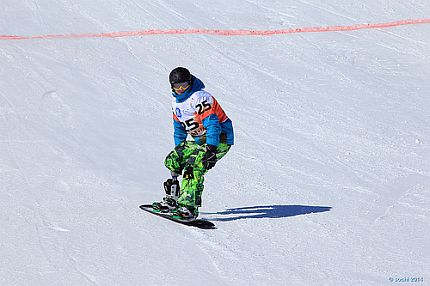 Zawodnik z protezą nogi zjeżdża po śniegu na desce snowboardowej